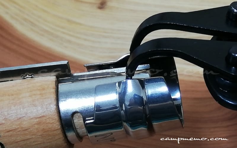 オピネルナイフのビロブロック（安全ロック）をスナップリングプライヤーで取り外しているところ